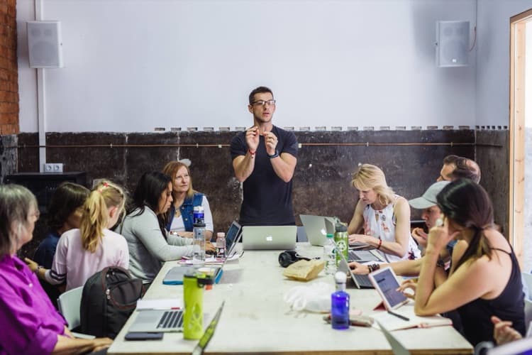 Delano leading a training workshop around a table